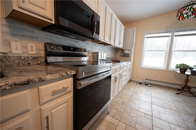 kitchen with tasteful backsplash, appliances with stainless steel finishes, a baseboard heating unit, stone finish floor, and dark stone counters