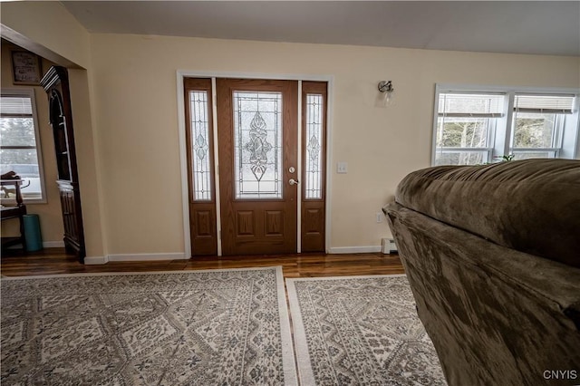 entrance foyer featuring a baseboard heating unit, baseboards, and wood finished floors