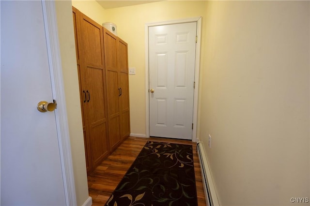 doorway to outside with dark wood-style floors, baseboards, and a baseboard heating unit