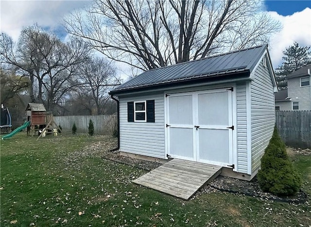 view of shed with a fenced backyard and a playground