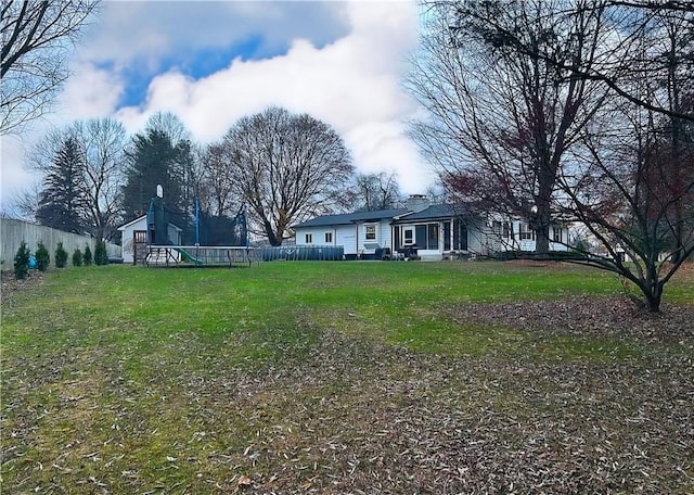 view of yard with a playground and fence