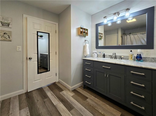 full bathroom with vanity, baseboards, and wood finished floors