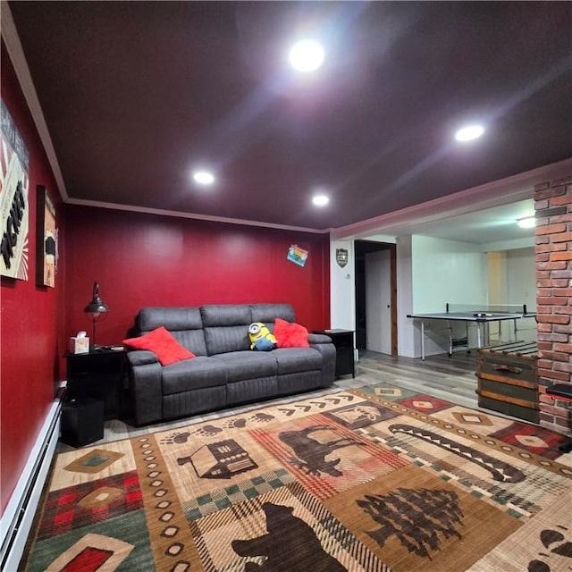 home theater room with ornamental molding, baseboard heating, wood finished floors, and recessed lighting