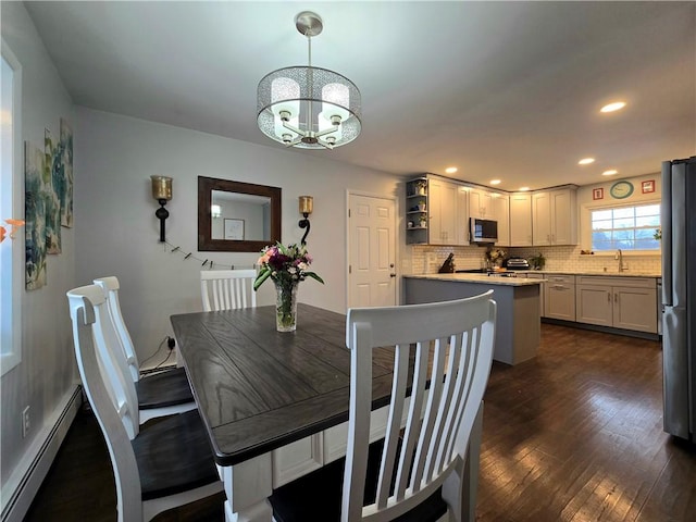 dining room featuring recessed lighting, dark wood-style flooring, baseboard heating, and an inviting chandelier