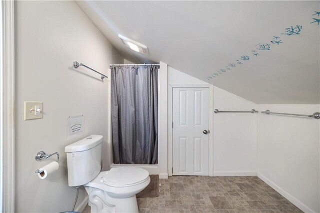 bathroom with vaulted ceiling, curtained shower, toilet, and baseboards