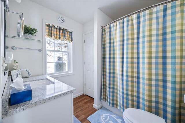 full bathroom with baseboards, toilet, a shower with curtain, wood finished floors, and vanity