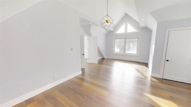 bonus room featuring high vaulted ceiling, baseboards, a chandelier, and wood finished floors