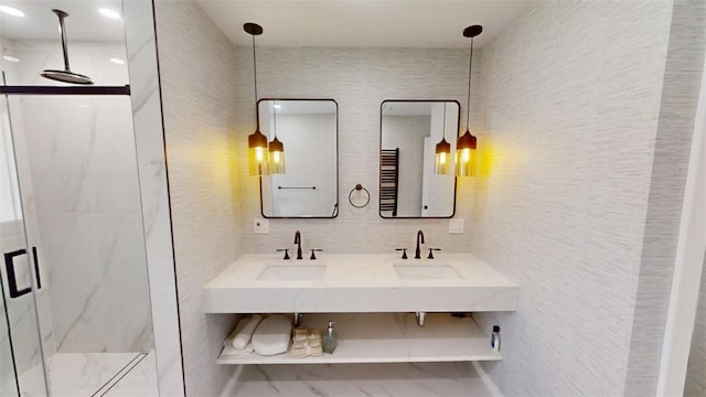 full bathroom with a sink, tile walls, a marble finish shower, and double vanity