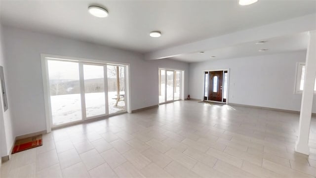 unfurnished room with baseboards