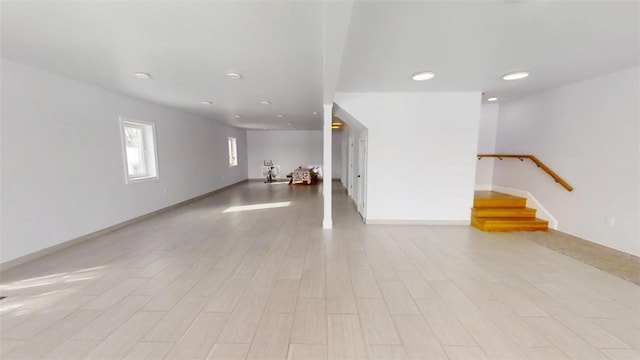 interior space featuring light wood-style flooring, stairs, and baseboards