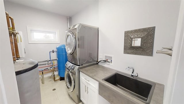 washroom with a sink, cabinet space, and stacked washer / drying machine