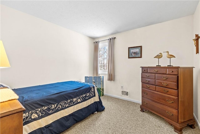 bedroom featuring carpet floors, visible vents, a textured ceiling, and baseboards