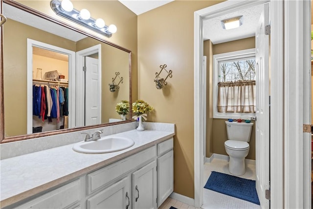 bathroom featuring vanity, toilet, and baseboards