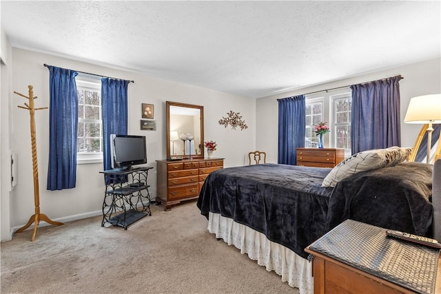 bedroom featuring light carpet, baseboards, and a textured ceiling