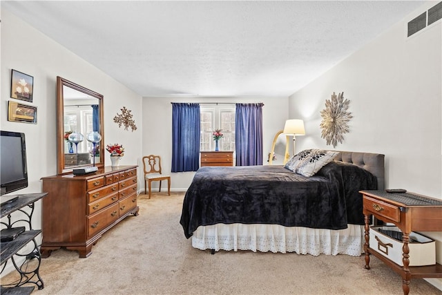 bedroom with visible vents, a textured ceiling, and light colored carpet