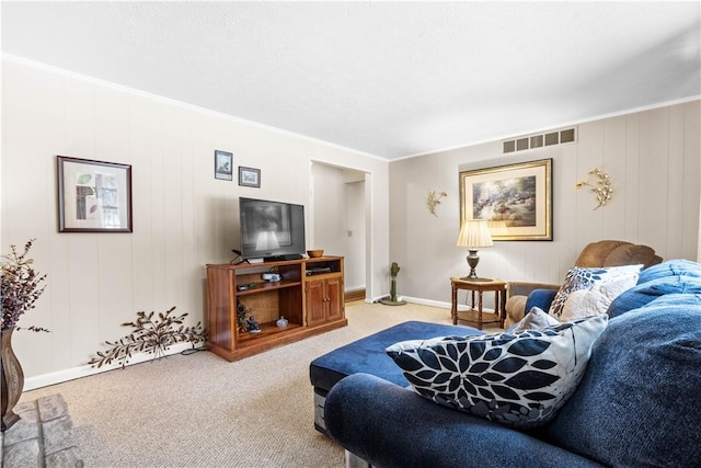 living room with ornamental molding, visible vents, and light carpet