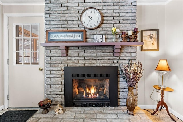 interior details featuring ornamental molding, a fireplace, and baseboards