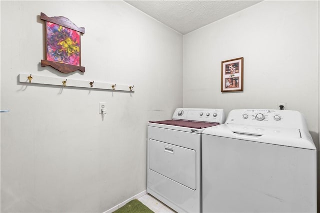 laundry room with baseboards, laundry area, a textured ceiling, and washer and dryer