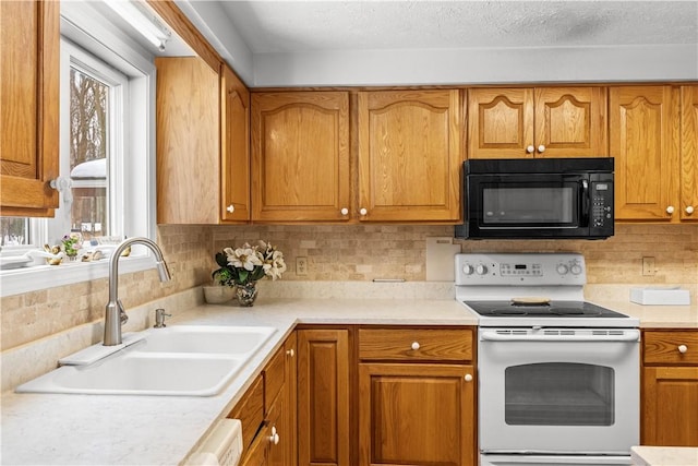 kitchen featuring white range with electric stovetop, brown cabinetry, light countertops, black microwave, and a sink