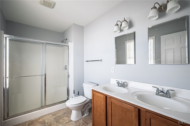 bathroom with a stall shower, visible vents, and a sink