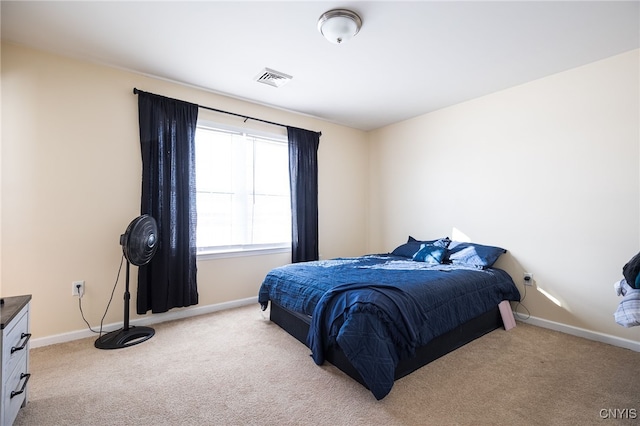 bedroom with light carpet, visible vents, and baseboards