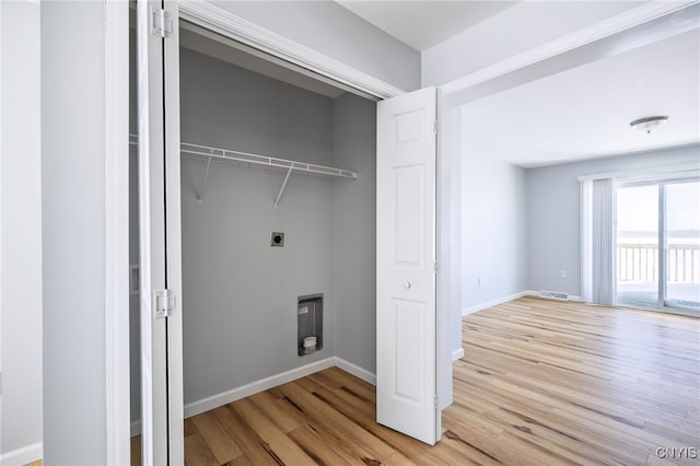 washroom with baseboards, laundry area, wood finished floors, and hookup for an electric dryer