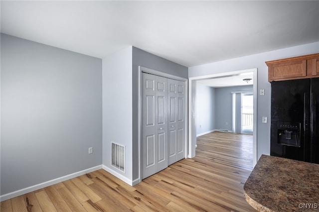 interior space featuring light wood-type flooring, baseboards, and visible vents