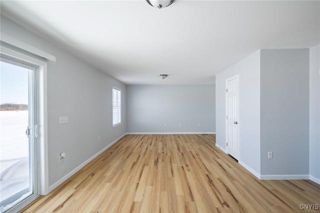 spare room featuring light wood-style flooring and baseboards