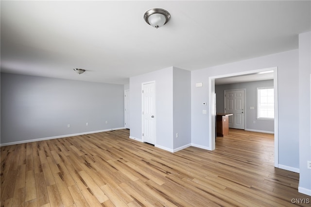 spare room with light wood-type flooring and baseboards