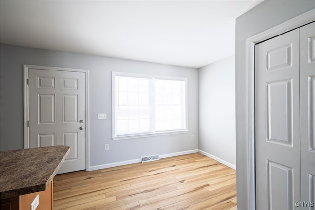 interior space with light wood finished floors, baseboards, and visible vents