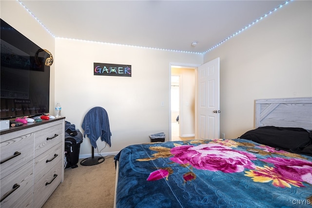 bedroom with baseboards and light colored carpet