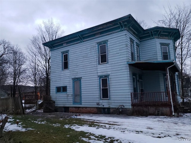 snow covered property featuring a porch