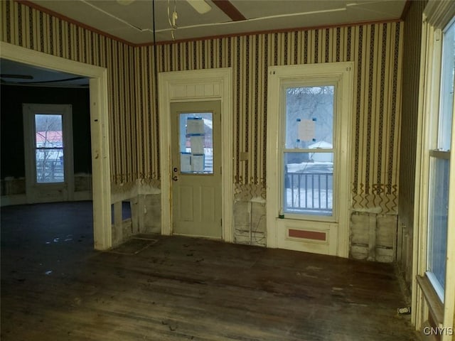 foyer entrance with wallpapered walls, ceiling fan, and wood finished floors