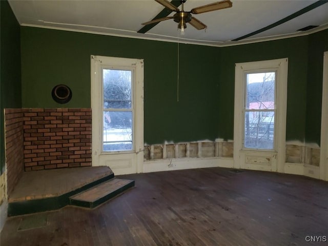 spare room with ceiling fan, crown molding, and wood finished floors