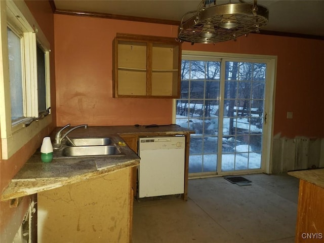 kitchen featuring ornamental molding, dark countertops, dishwasher, and a sink