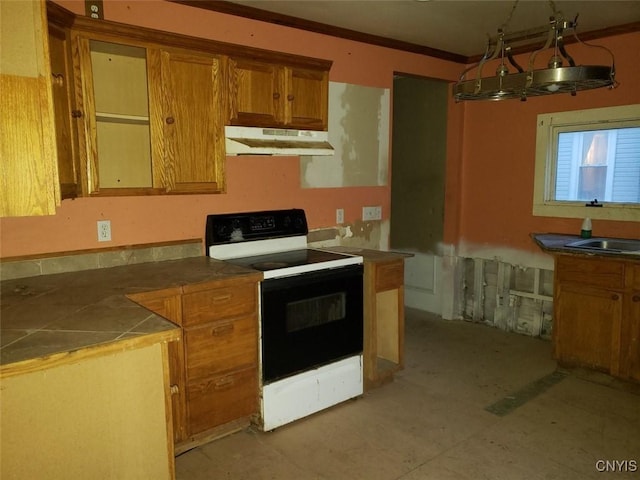 kitchen featuring range with electric cooktop, tile counters, brown cabinets, under cabinet range hood, and a sink