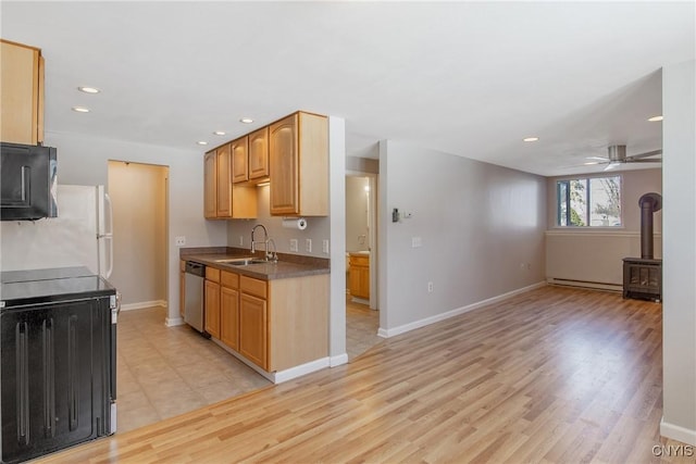 kitchen with recessed lighting, a sink, stainless steel dishwasher, light wood finished floors, and a wood stove