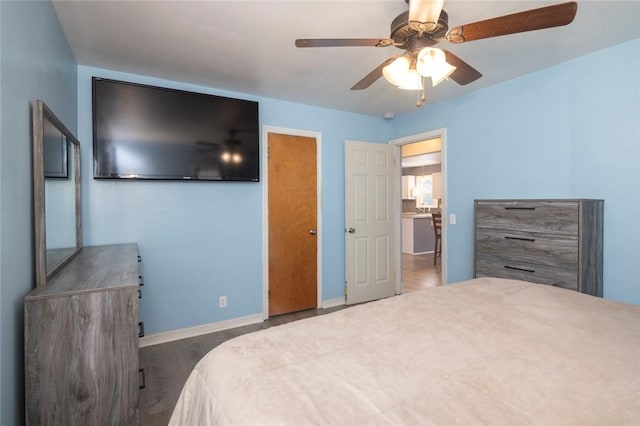 bedroom with wood finished floors, a ceiling fan, and baseboards