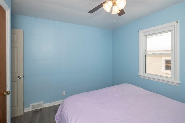 bedroom featuring dark wood-type flooring, visible vents, ceiling fan, and baseboards