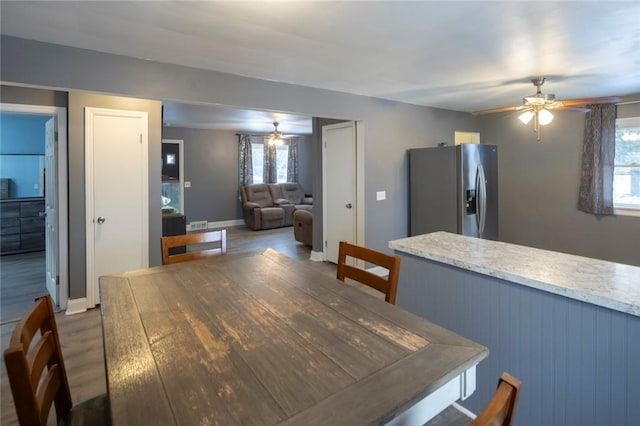 dining space with wood finished floors, a wealth of natural light, and a ceiling fan