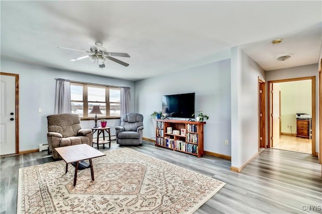 living area with baseboard heating and wood finished floors