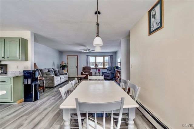 dining room with ceiling fan, light wood-type flooring, and a baseboard radiator