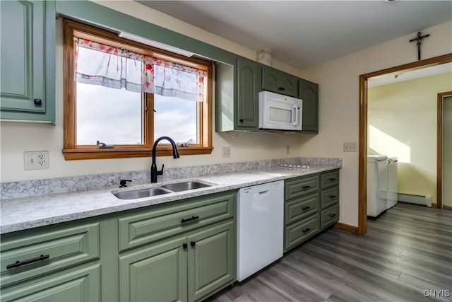 kitchen featuring white appliances, a sink, washer and clothes dryer, and green cabinets