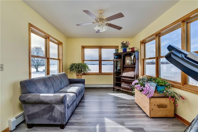 sitting room featuring a baseboard radiator, baseboards, ceiling fan, and wood finished floors