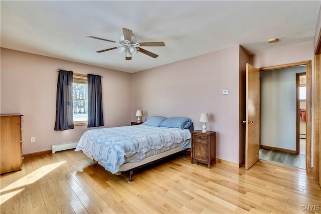 bedroom featuring baseboards, ceiling fan, baseboard heating, and light wood-style floors