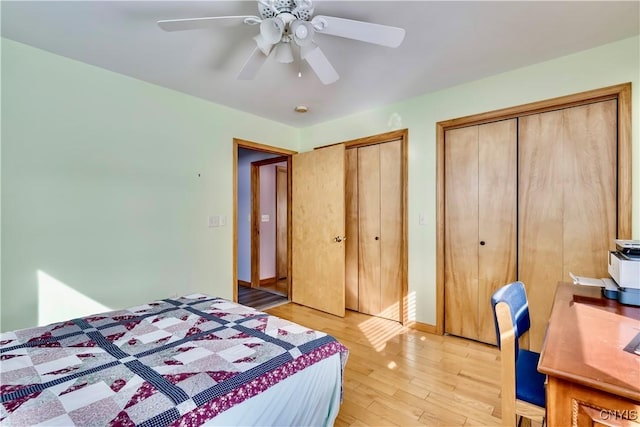 bedroom with multiple closets, baseboards, ceiling fan, and light wood finished floors