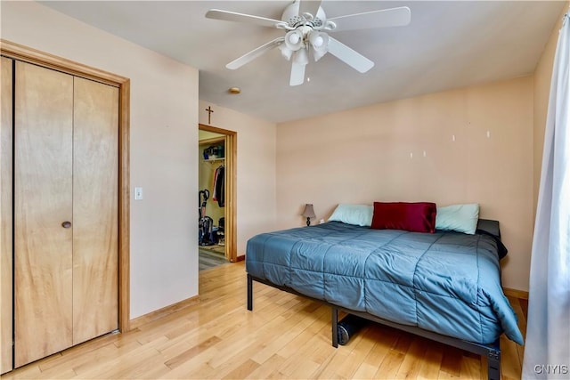 bedroom featuring ceiling fan, a closet, light wood-style flooring, and baseboards