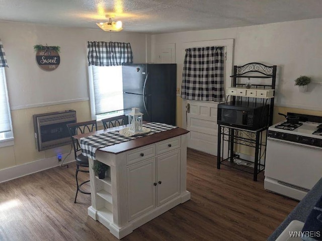 kitchen featuring dark wood-type flooring, white cabinets, black appliances, and open shelves