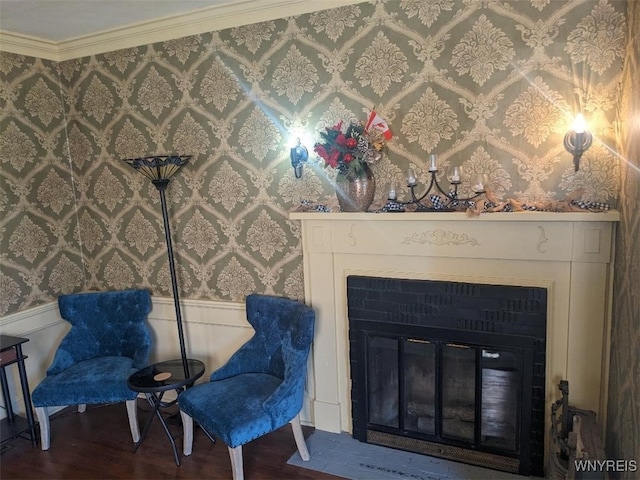 sitting room featuring wallpapered walls, a glass covered fireplace, and wainscoting