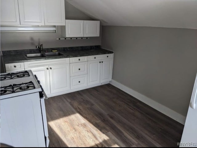 kitchen featuring lofted ceiling, dark wood-type flooring, white cabinetry, a sink, and white gas range oven